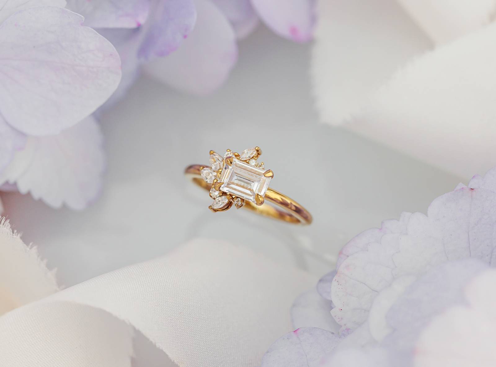 Asymmetric Halo Ring With East-West Emerald Cut Center Stone