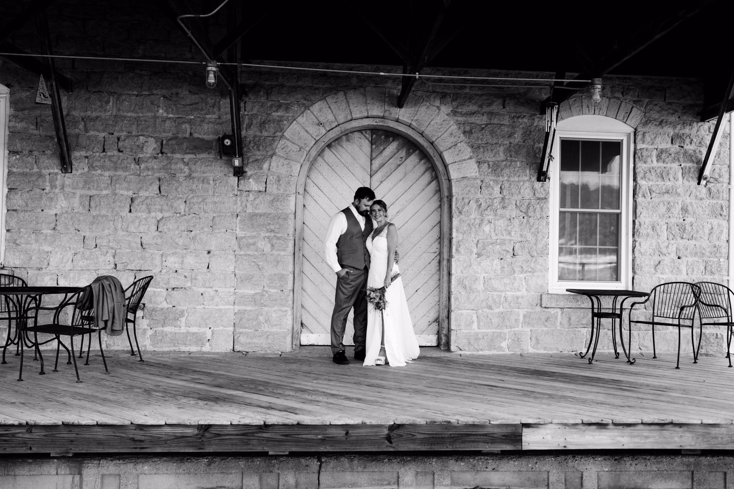 Bride and groom on the outdoor deck at The Mill on Rush Creek historic venue in Rushford, MN