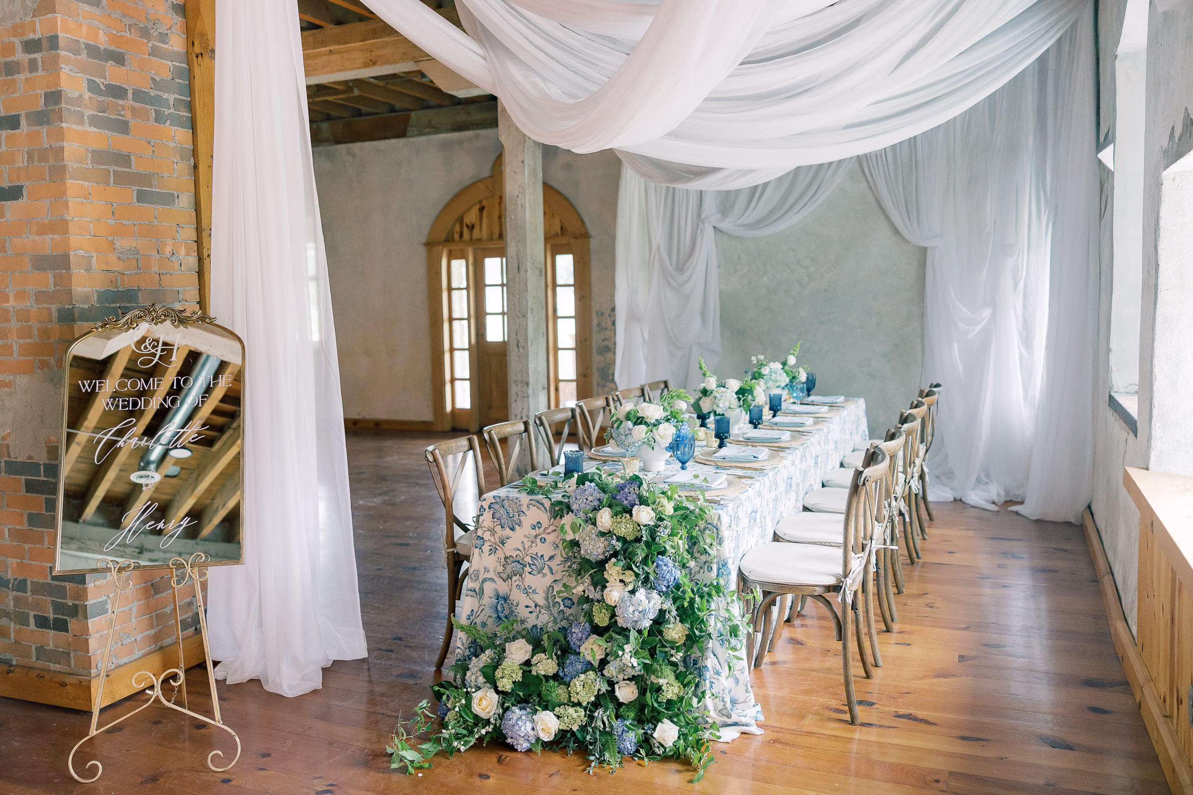 Blue and white garden wedding inspiration tablescape with floral linen and lush greenery