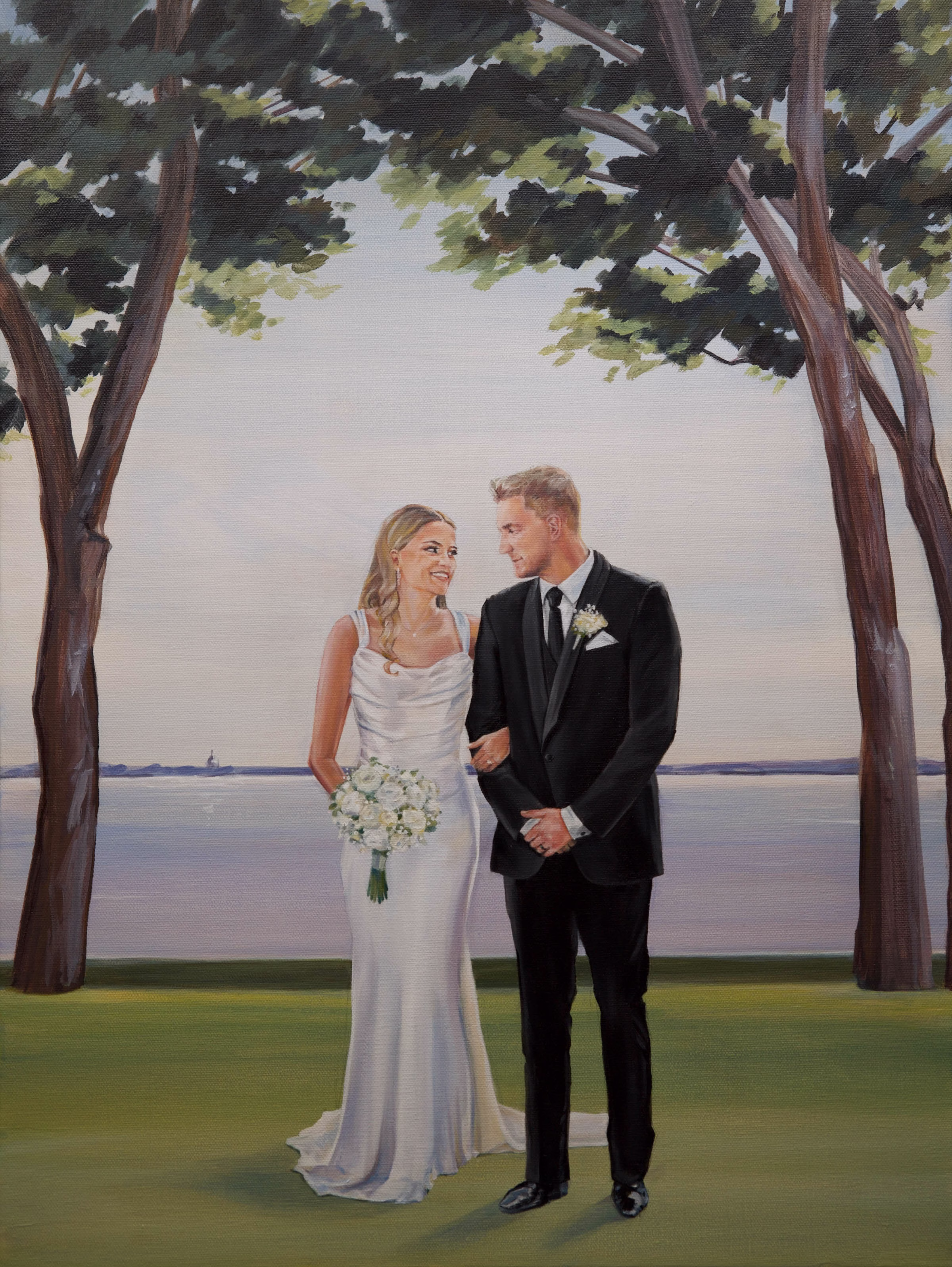A finished live wedding painting by The Artist Brenda Berg, depicting a bride and groom standing close together on a grassy lawn. The bride wears a sleek, sleeveless white gown and holds a white floral bouquet, while the groom wears a classic black tuxedo with a white boutonniere. They are framed by tall trees with full green canopies, with a wide, calm body of water and a distant shoreline under a pale sky behind them.