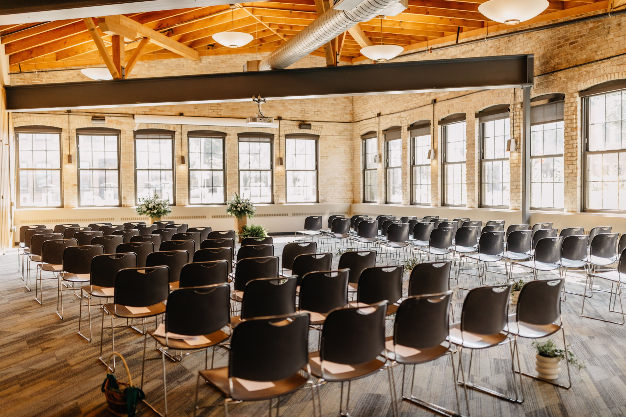 the ceremony setup at Goodman Community Center in Madison, Wisconsin, showing the venues abundant natural light and vaulted ceiling with exposed wooden beams