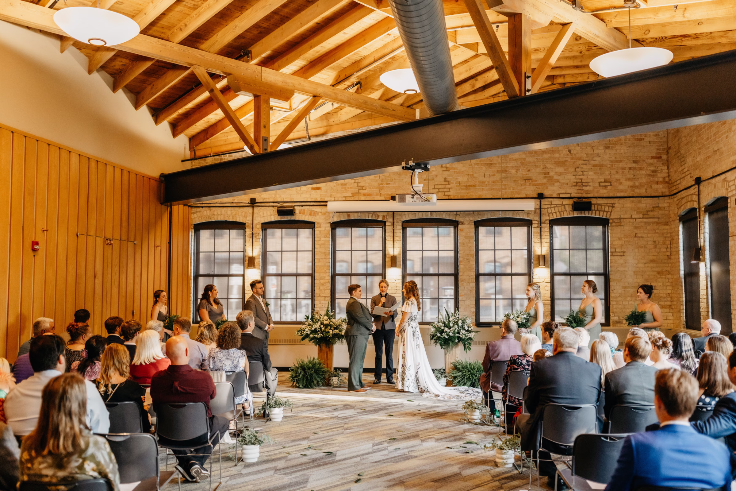 a view of Sam & Janine's wedding ceremony showing the brides and their wedding party