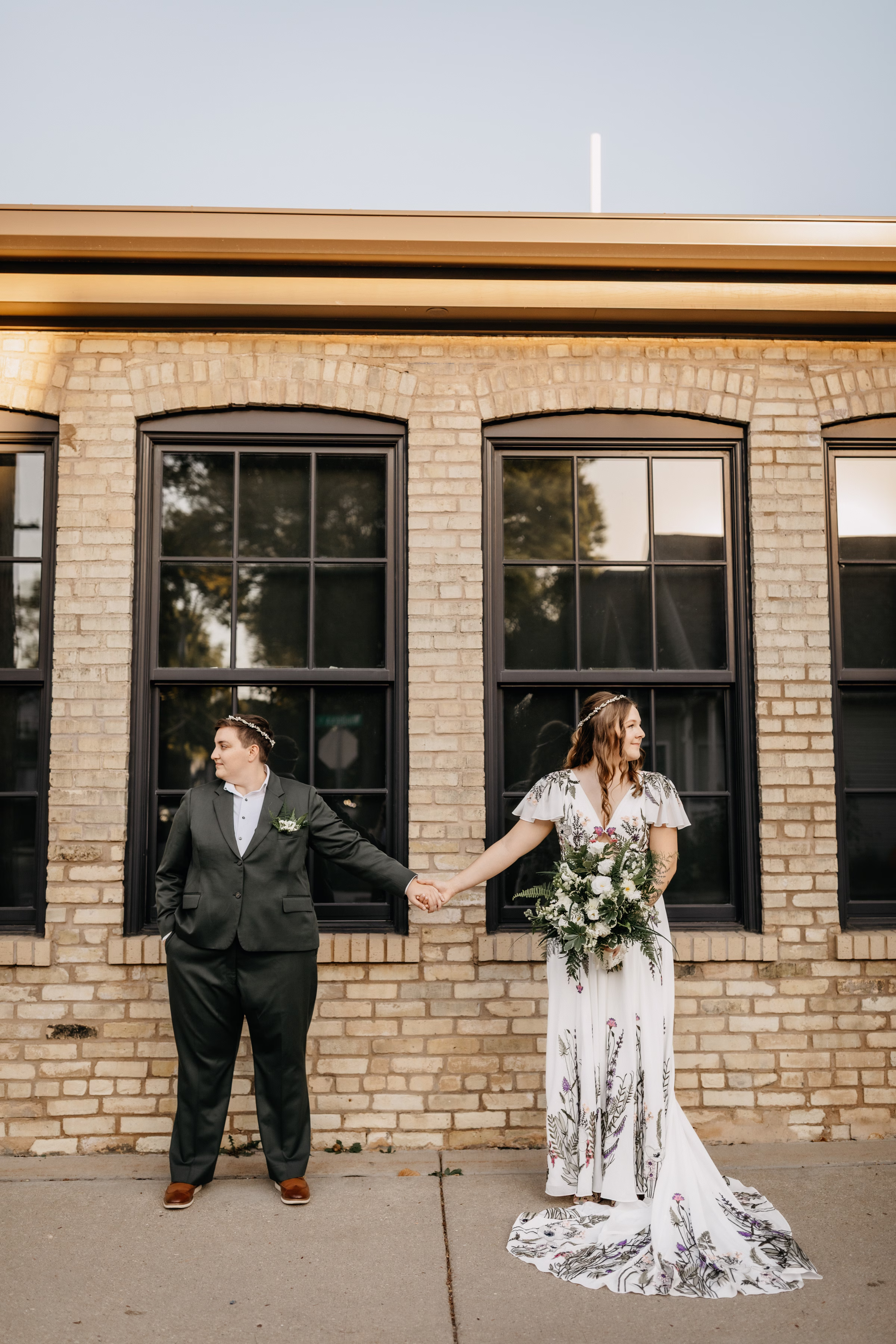 Sam & Janine hold hands in front of Goodman Community Center