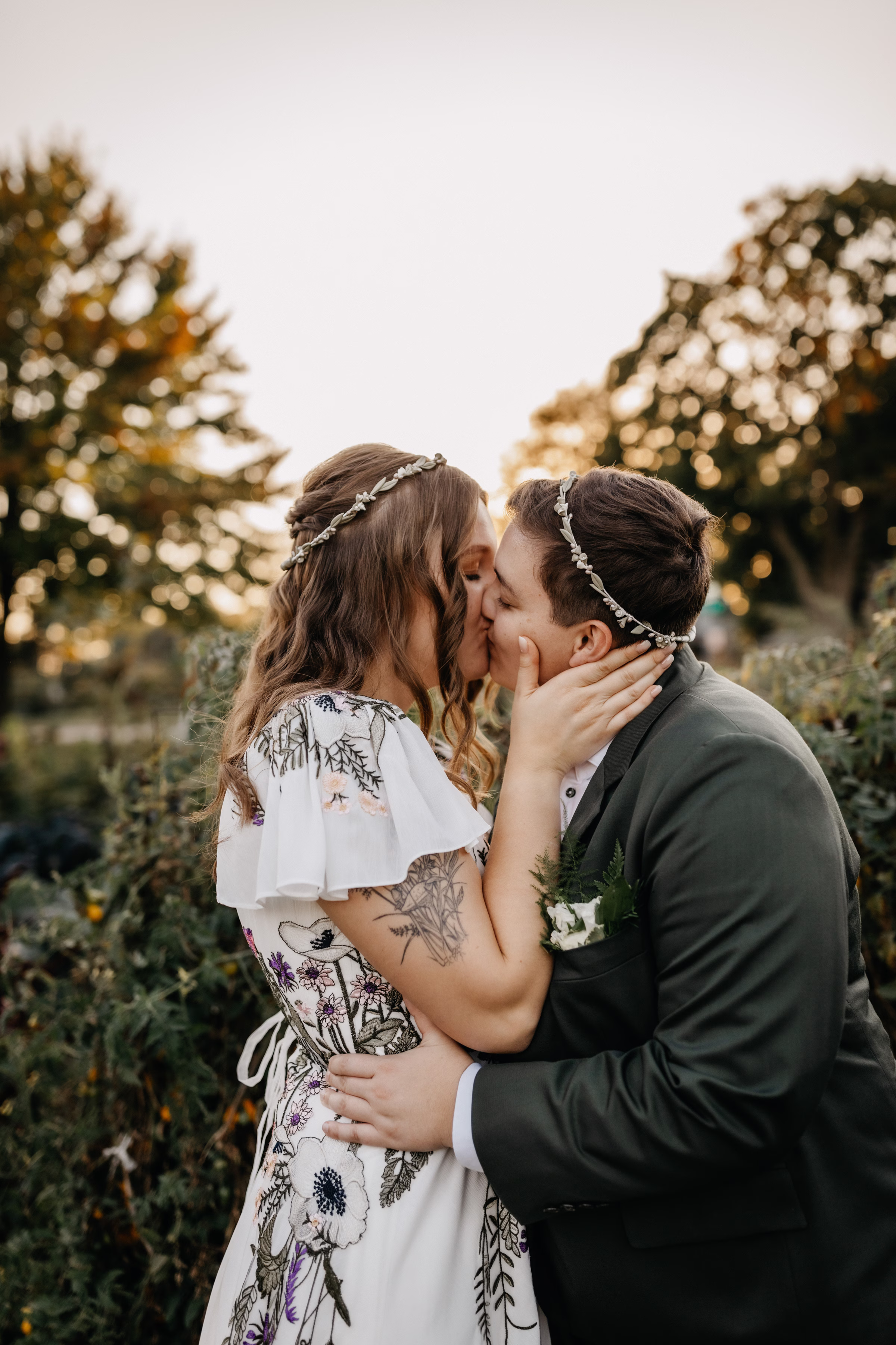 the brides kiss at golden hour wearing traditional Greek crowns