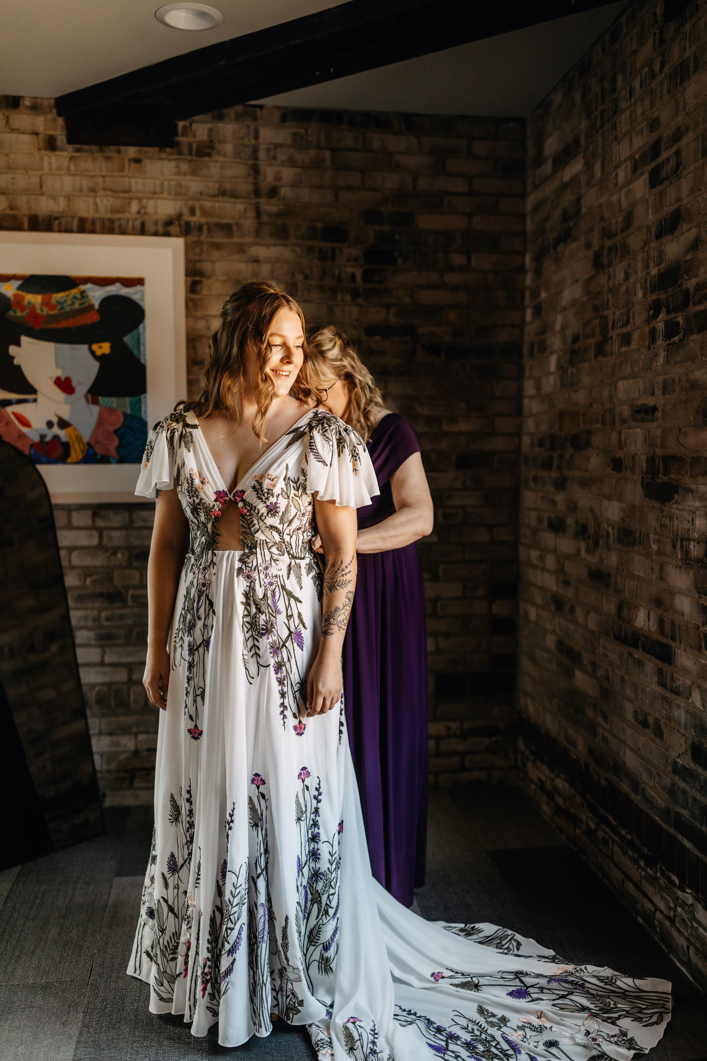 a bride prepares for her wedding day as the corset is tied on her dress