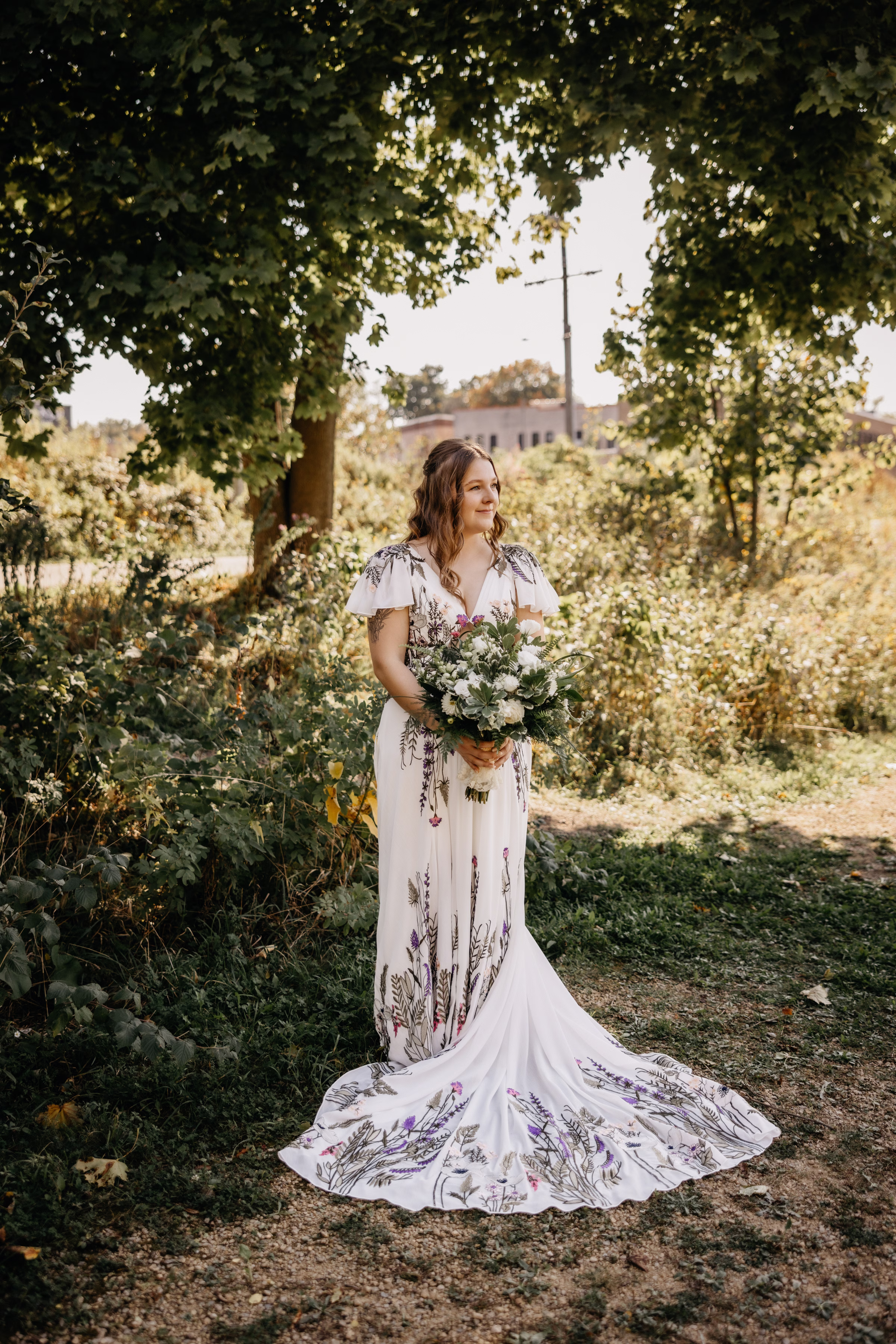 a portrait of Sam with her bouquet surrounded by greenery