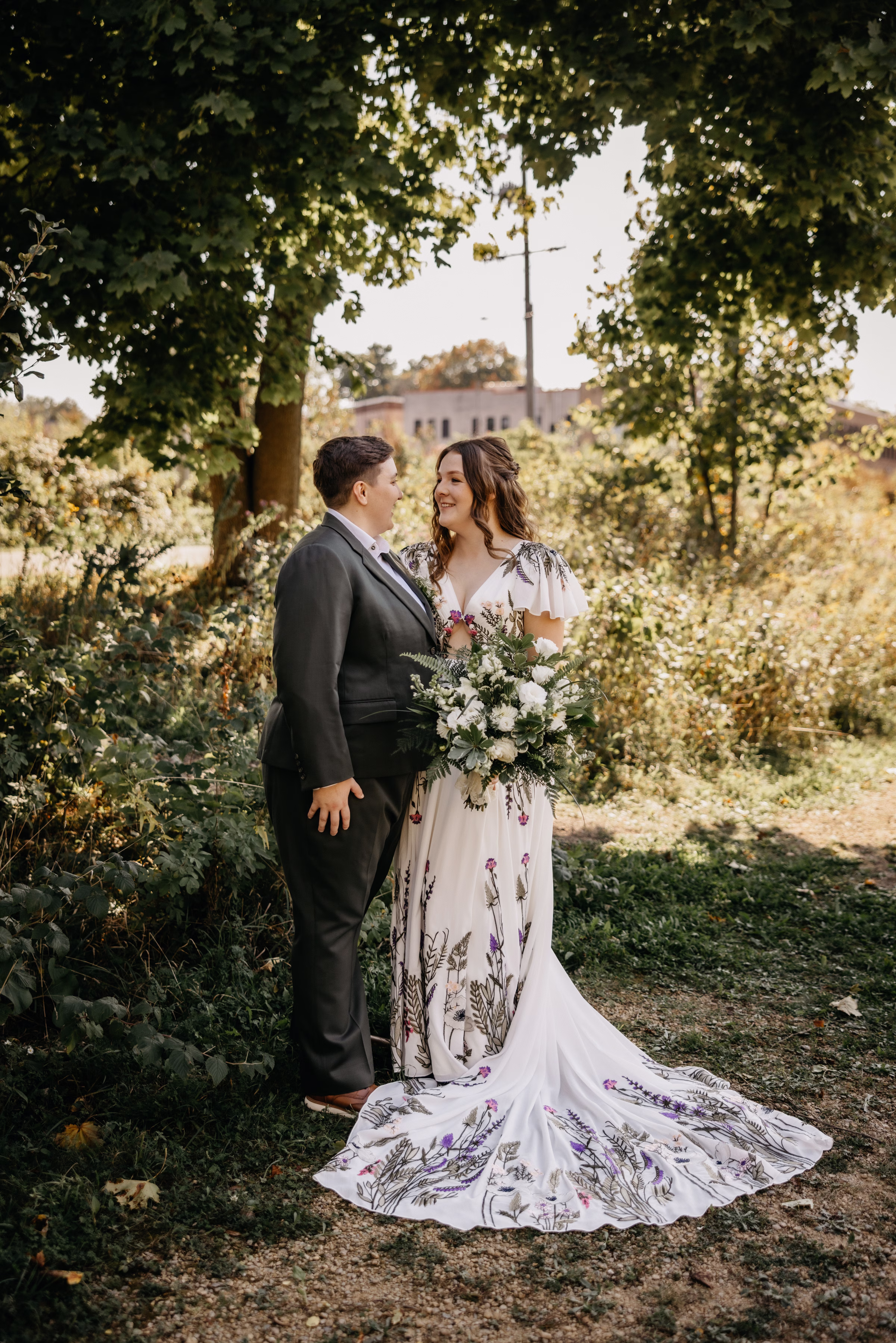 Sam and Janine smile at each other, surrounded by natural greenery at Goodman Center
