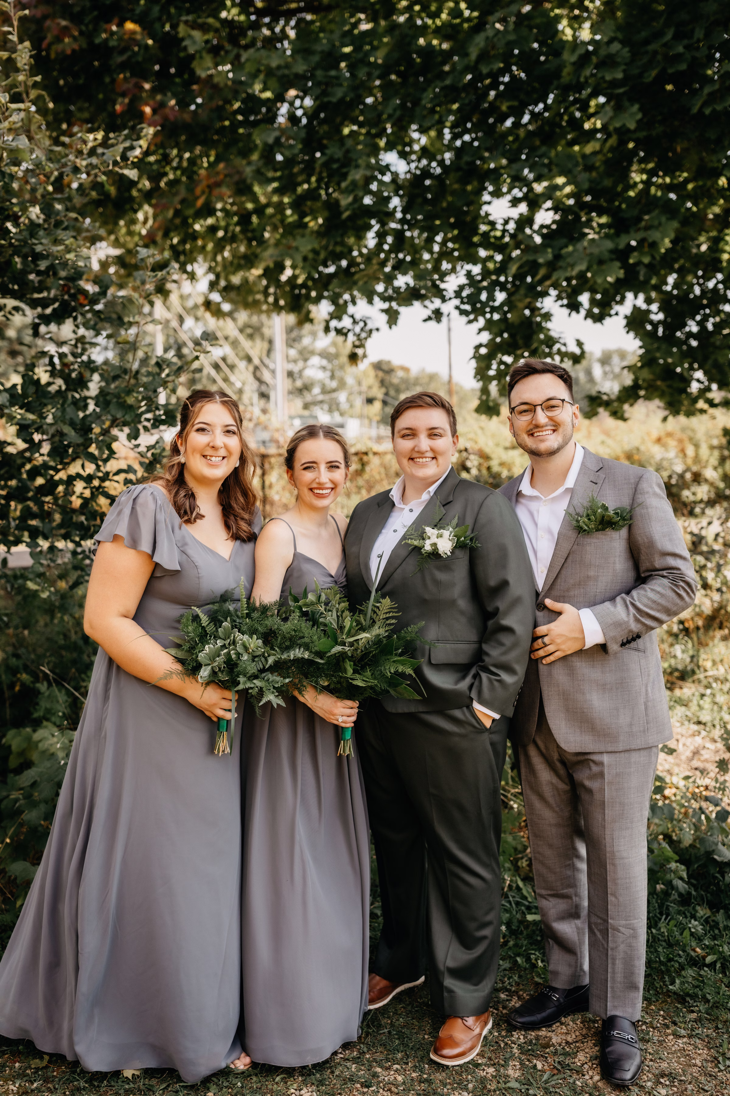 Janine poses alongside her wedding party wearing gray