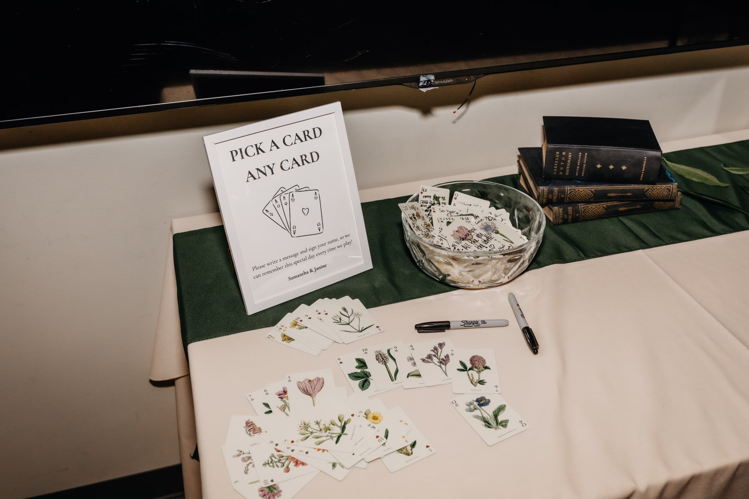 guests sign botanical cards in a deck of cards for the couple