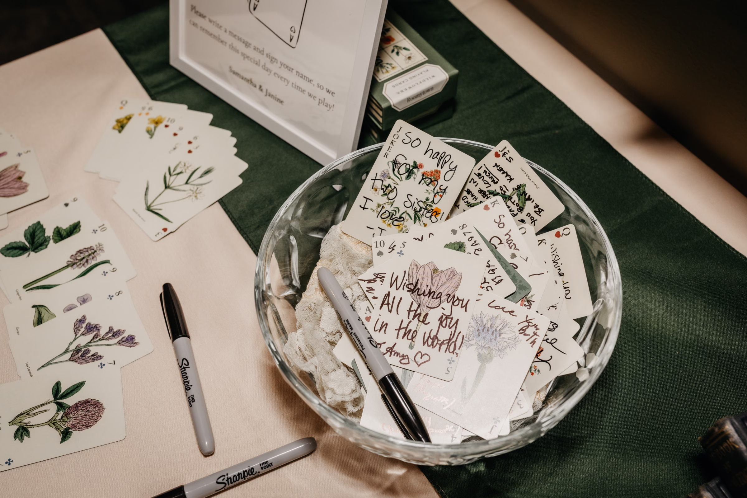 guests sign botanical cards in a deck of cards for the couple