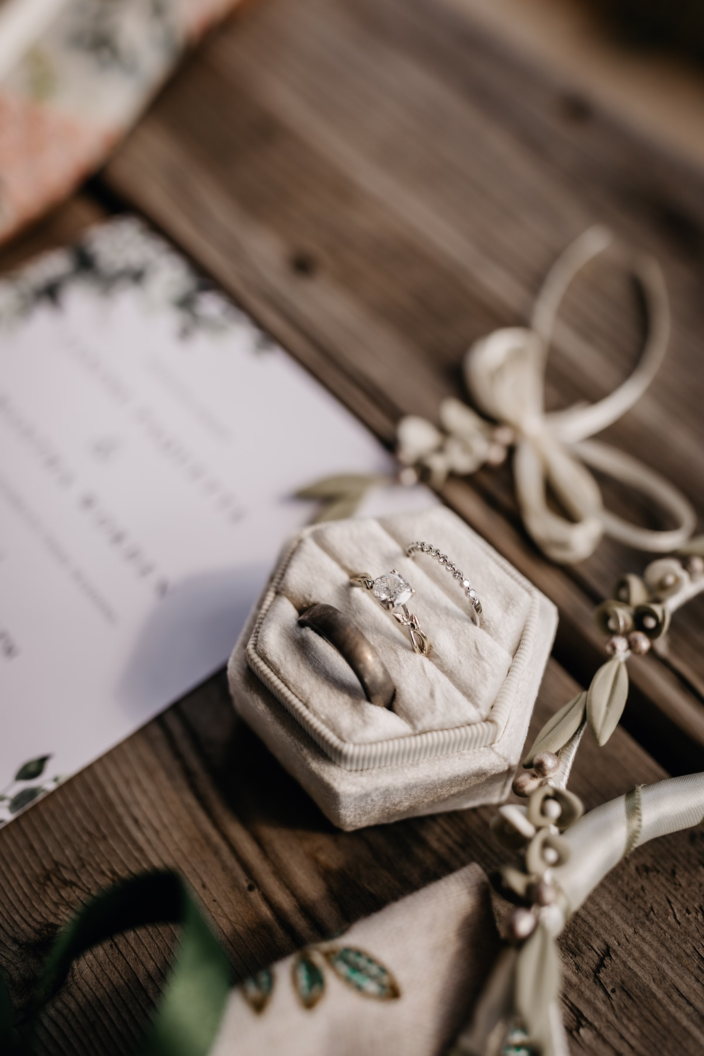 a detail shot of the couple's rings in a taupe ring holder