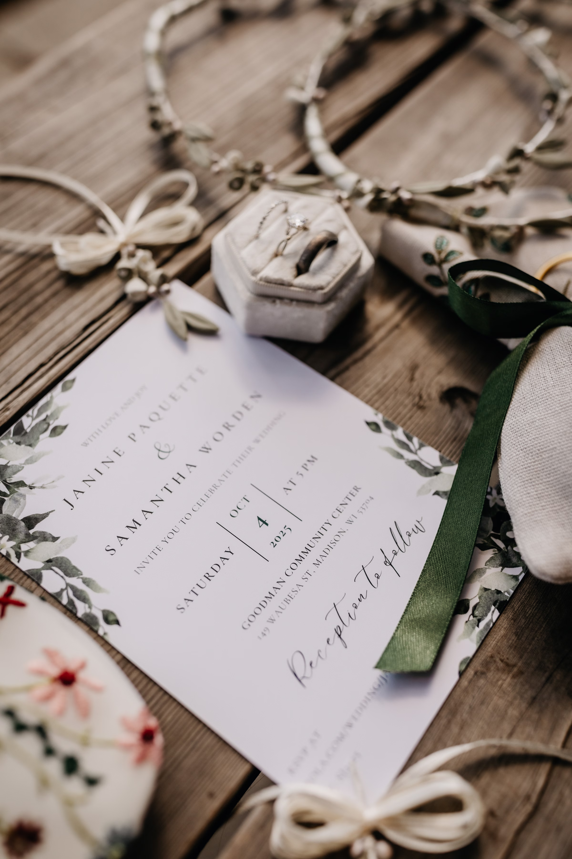 a photo of the couple's invitation beside colorful embroidered bridal flats, taupe and green earrings, and accessories