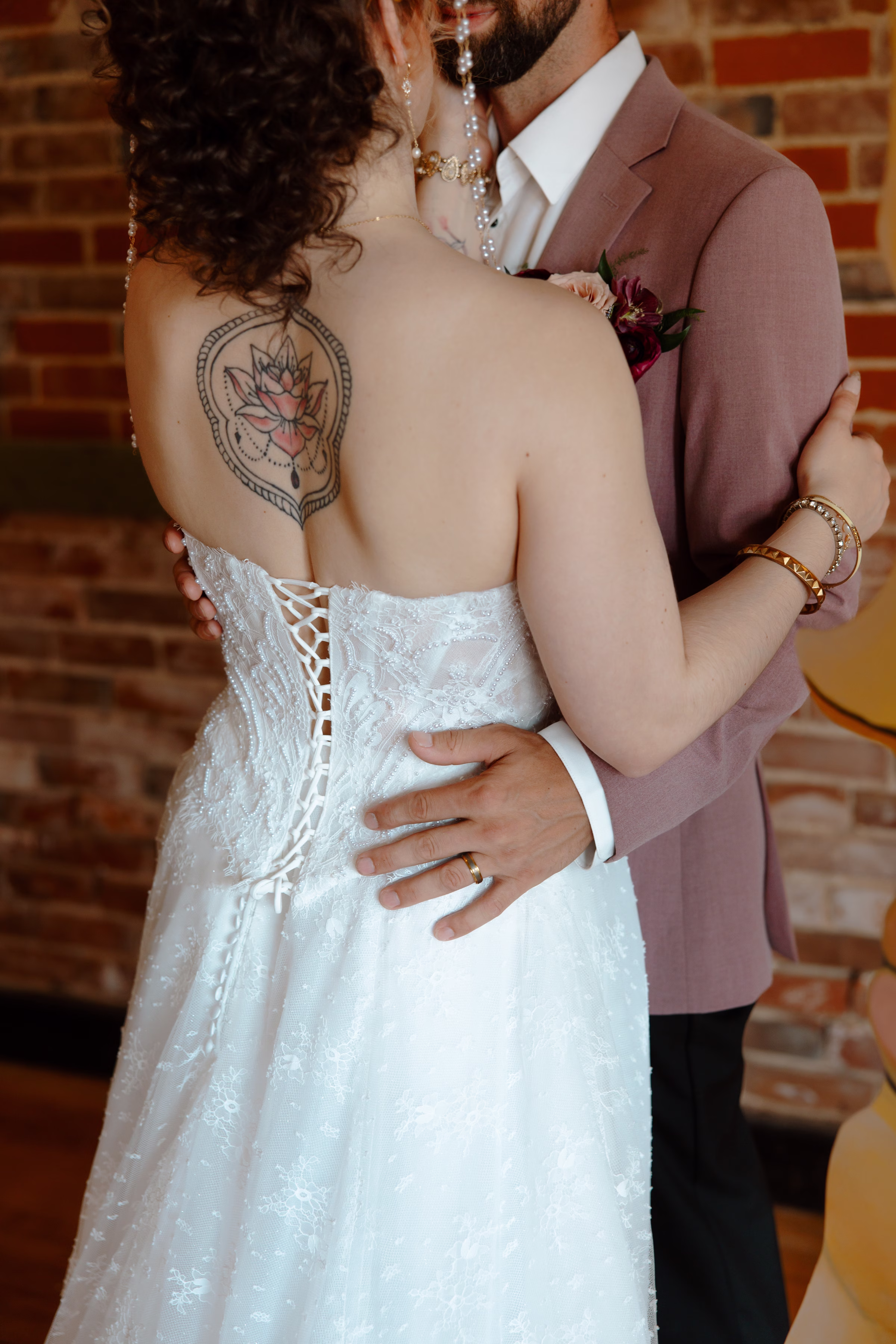 a detail photo showing the back of the bride's dress, a lace corset bodice, from Charlotte's Bridal & Formal Wear