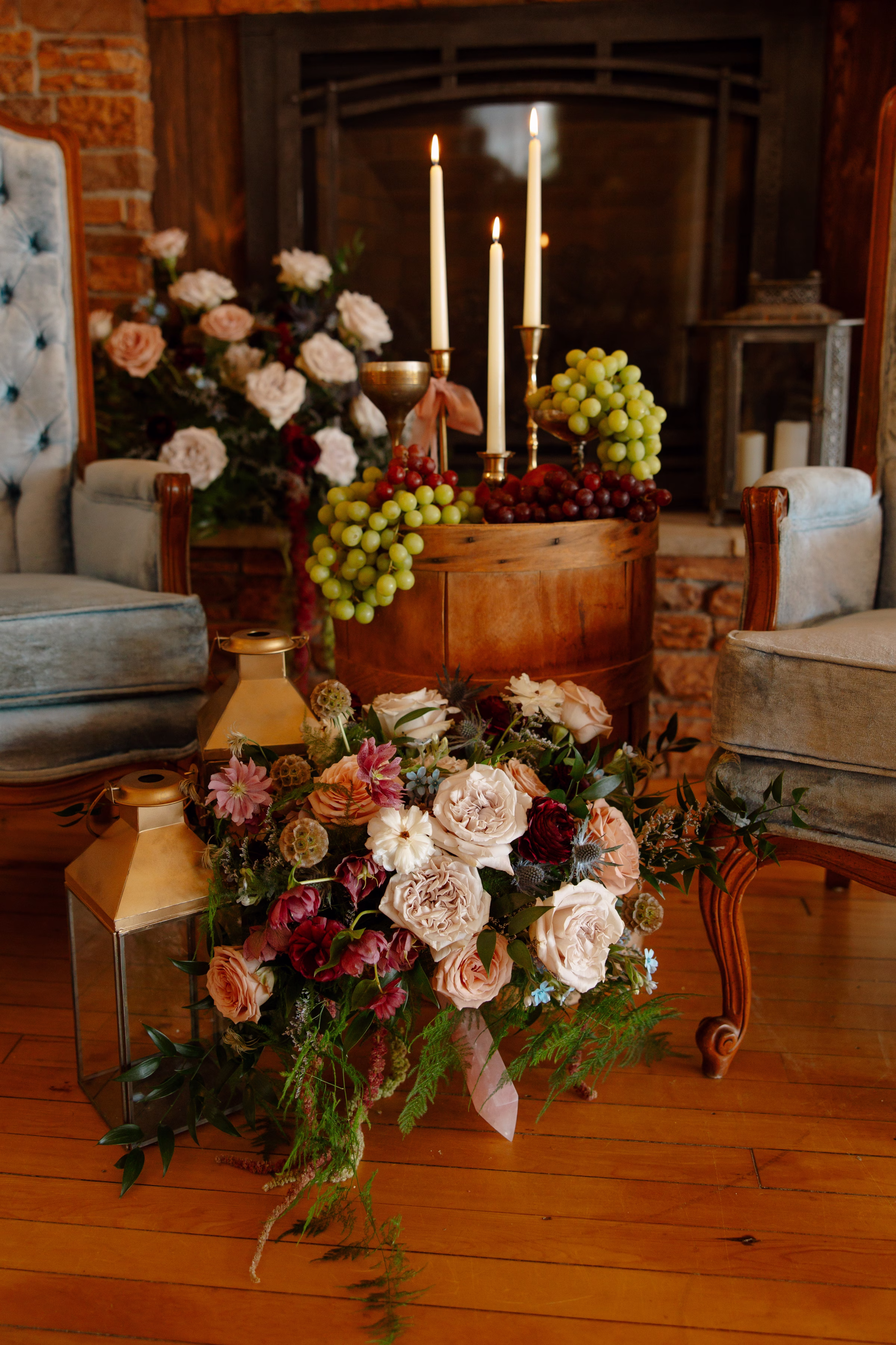 fruit as décor shown alongside candles, lanterns, florals, and two d dusty blue velvet chairs at B's Place Event Venue in West Salem, Wisconsin