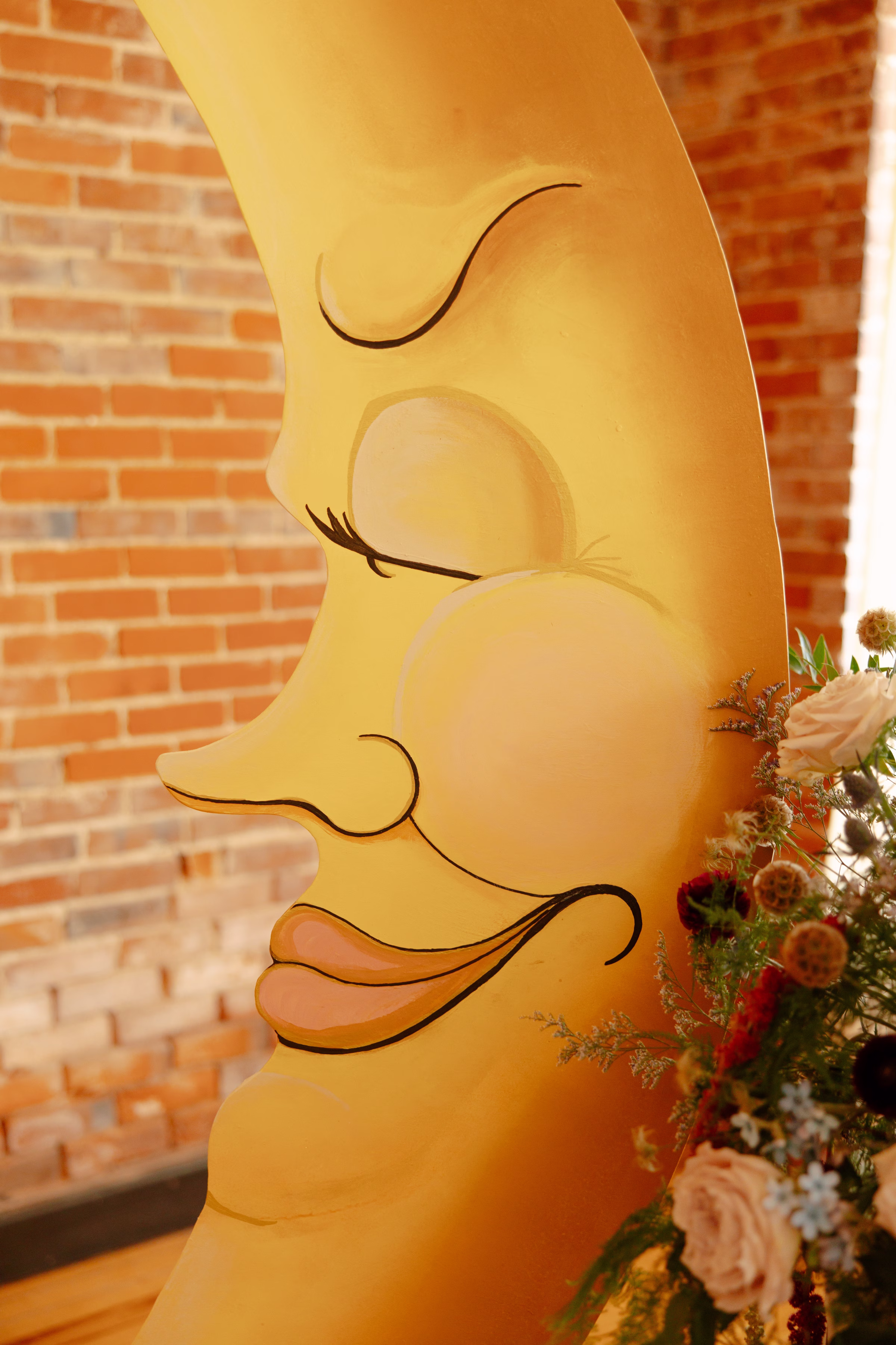 a close-up of the serene, painted crescent moon wedding ceremony backdrop