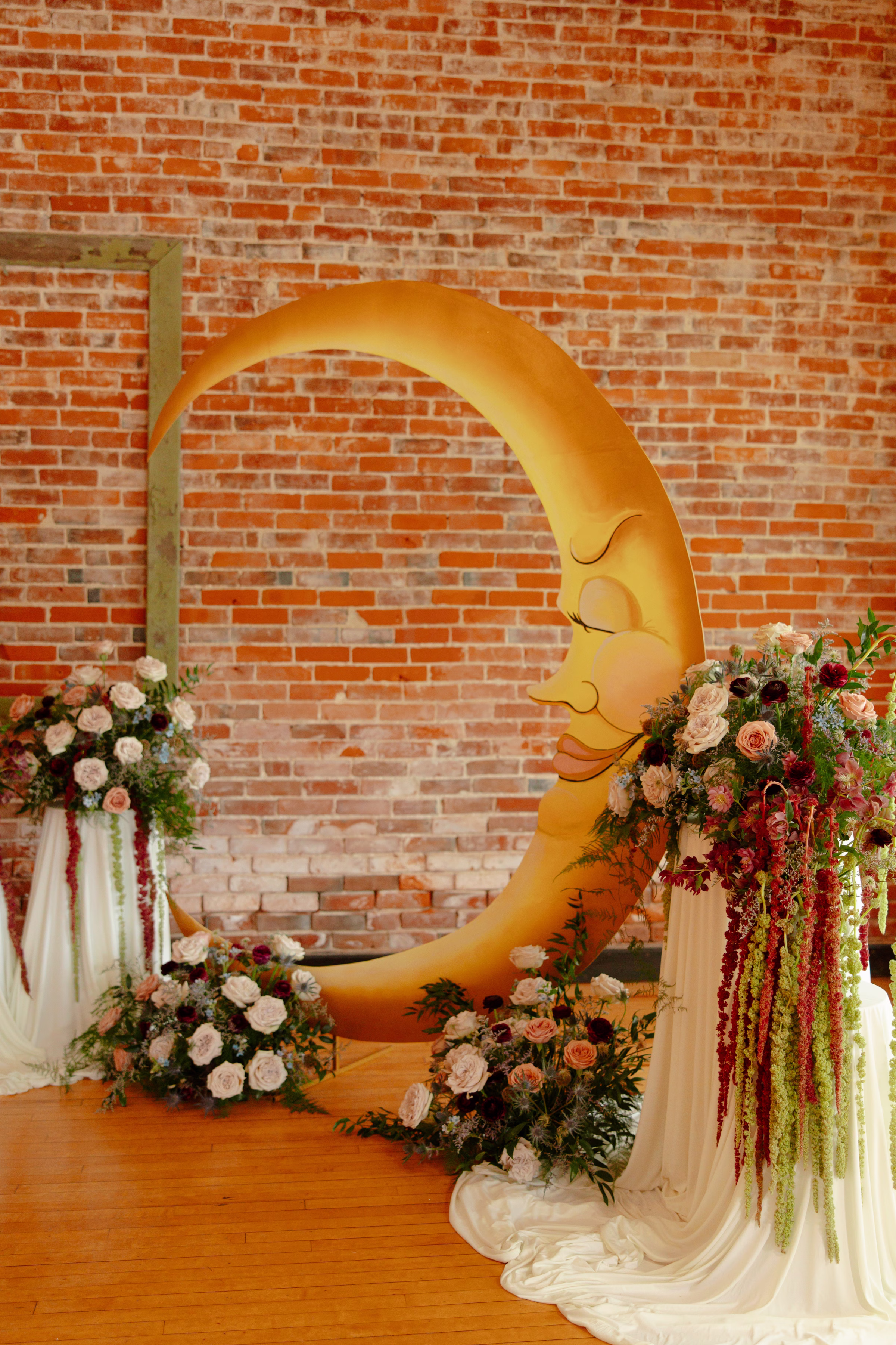 an angled view of the serene, painted crescent moon wedding ceremony backdrop