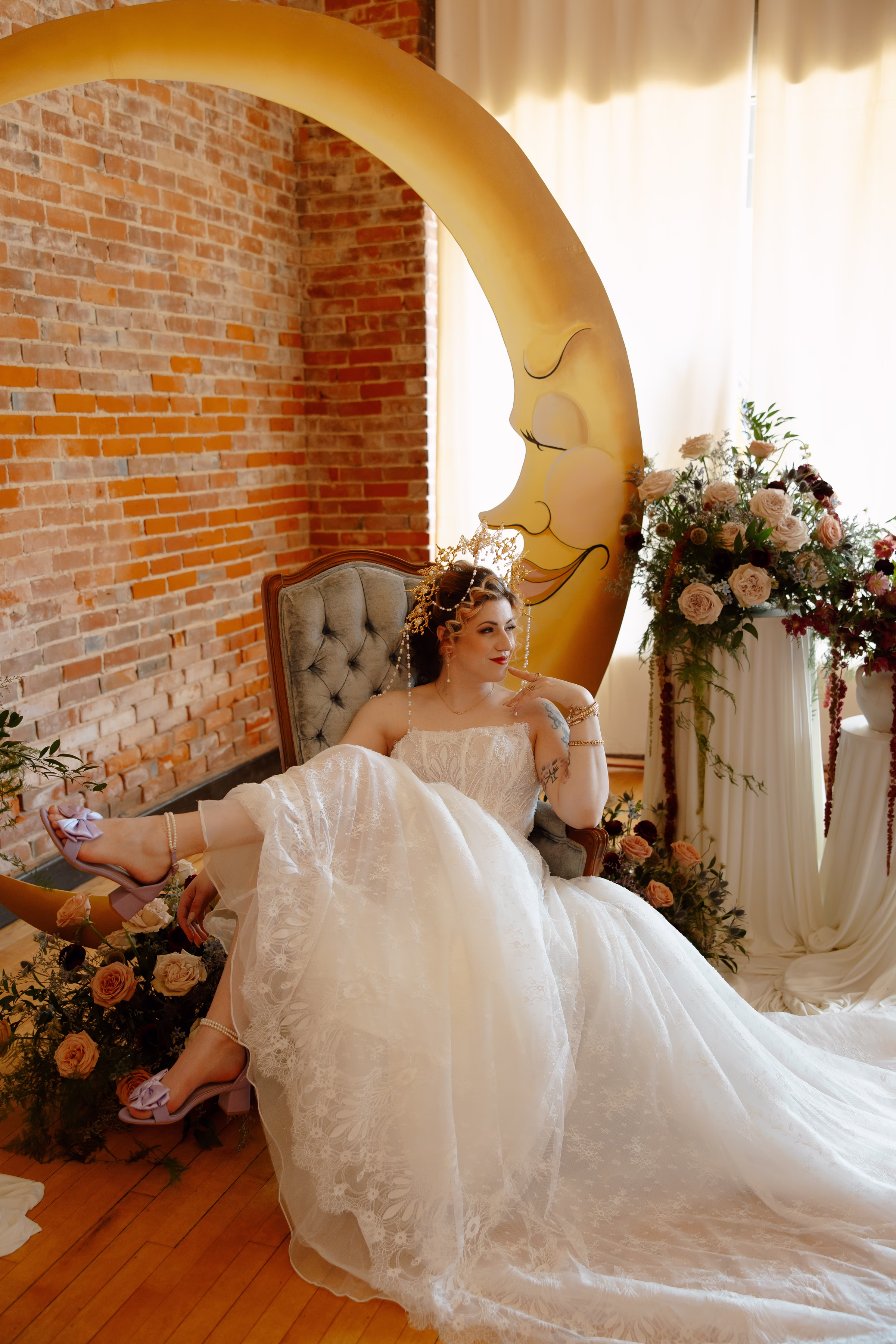 the bride lounges in a blue velvet chair from Resource Vintage Rental at a celestial-inspired wedding ceremony at B's Place Event Venue