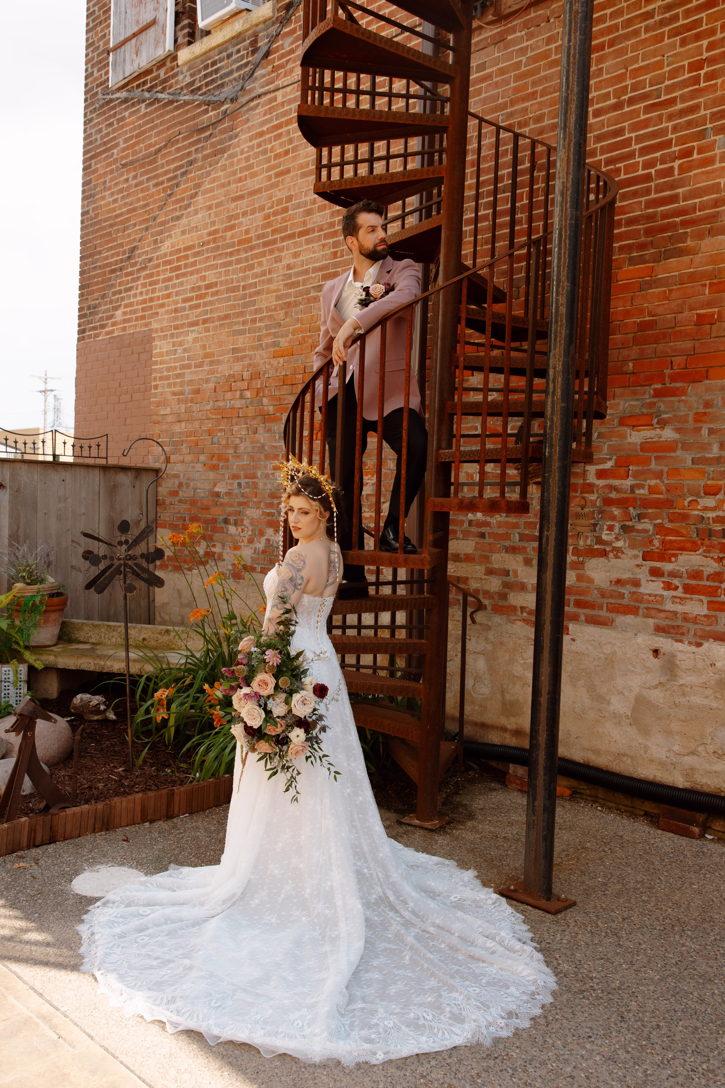 a bride and groom pose on an outdoor spiral staircase at B's Place Event Venue in West Salem, Wisconsin