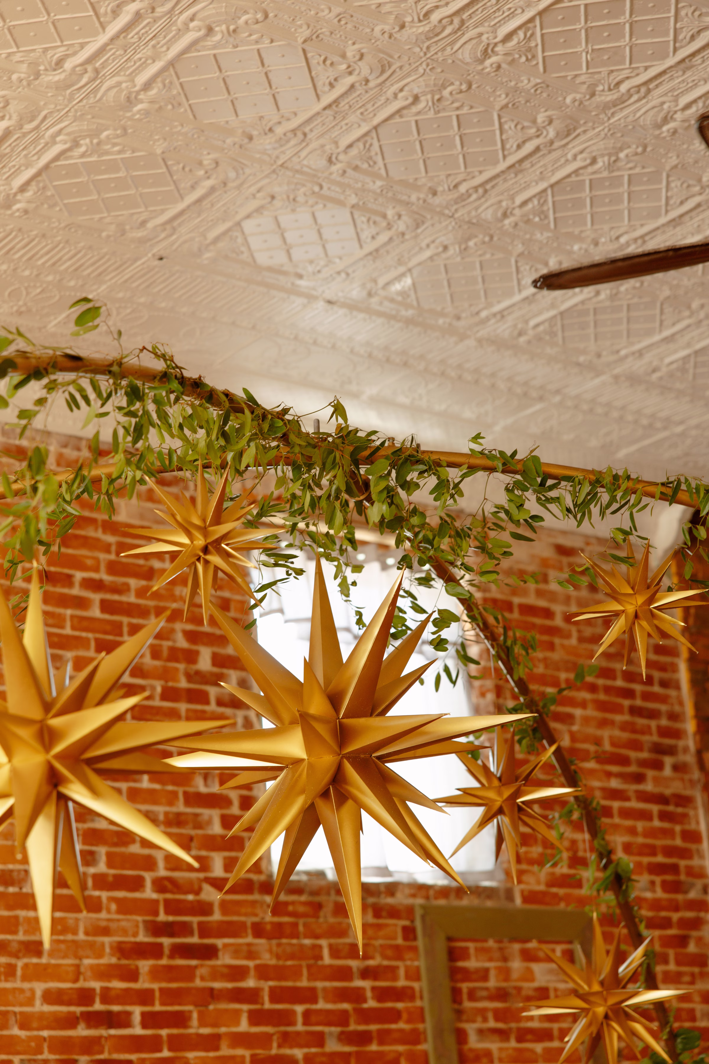 a detail photo of the gold star décor hung from an arch above the sweetheart table