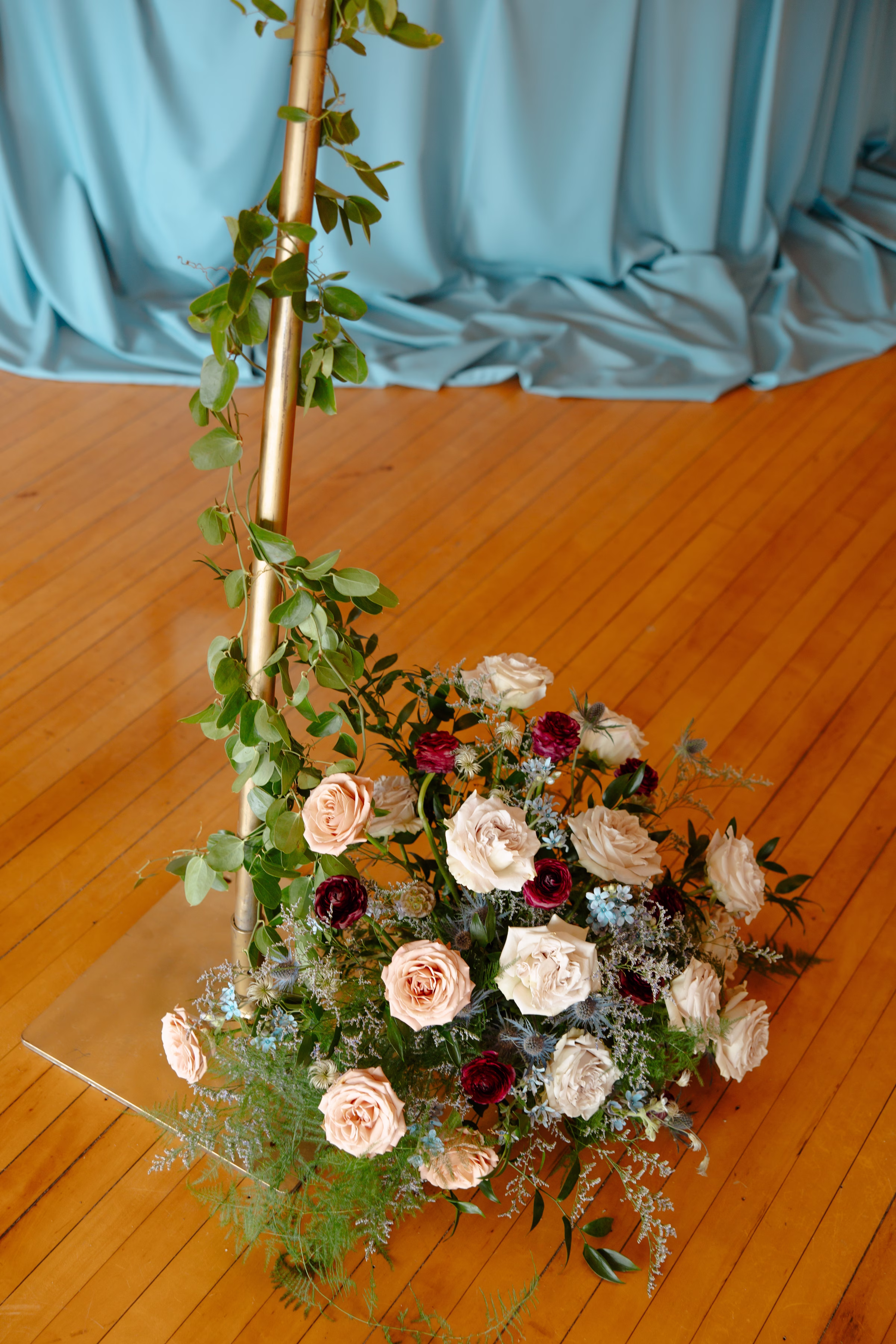a detail photo of the florals set at the foot of the arches surrounding the sweetheart table