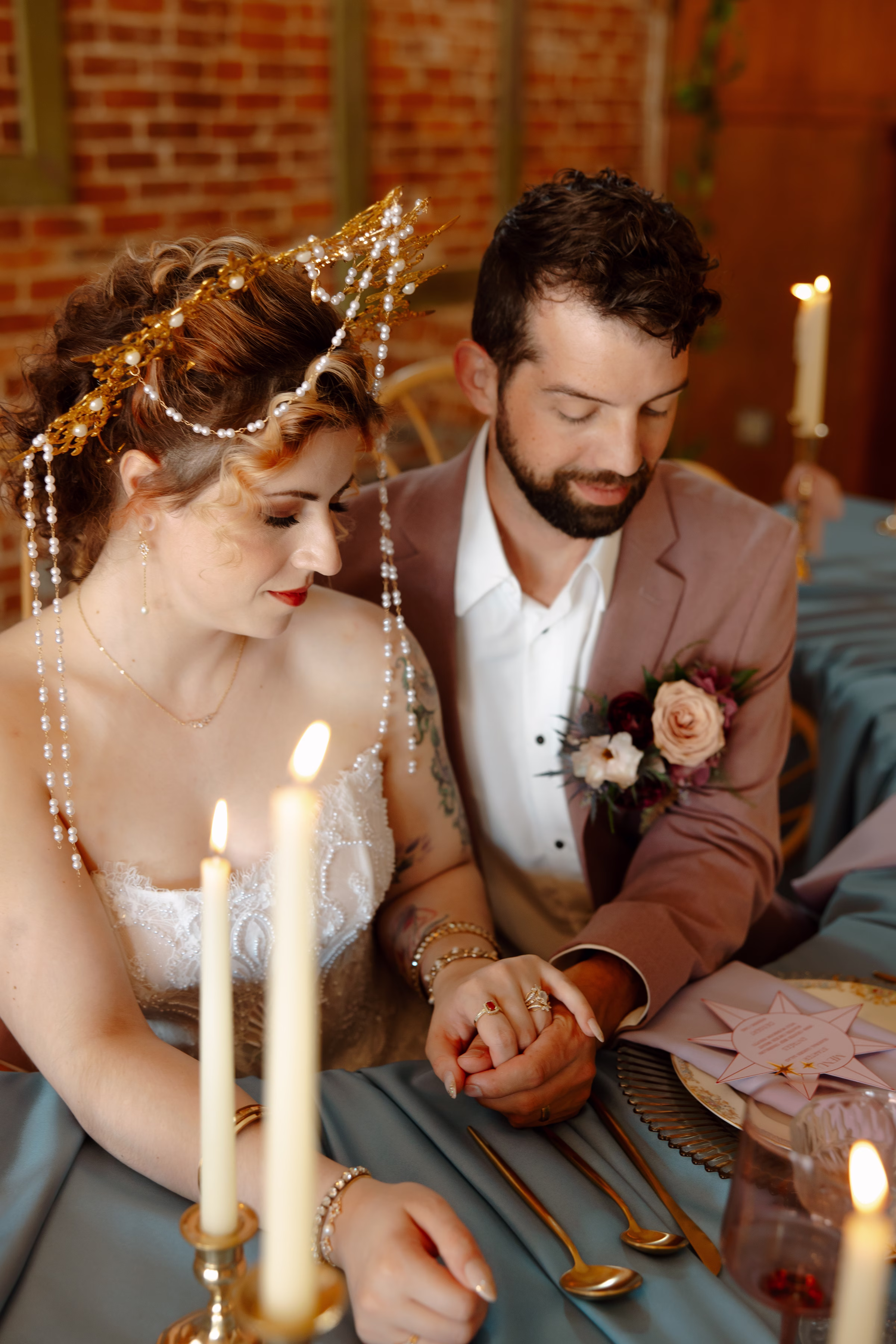 the couple holds hands at the sweetheart table
