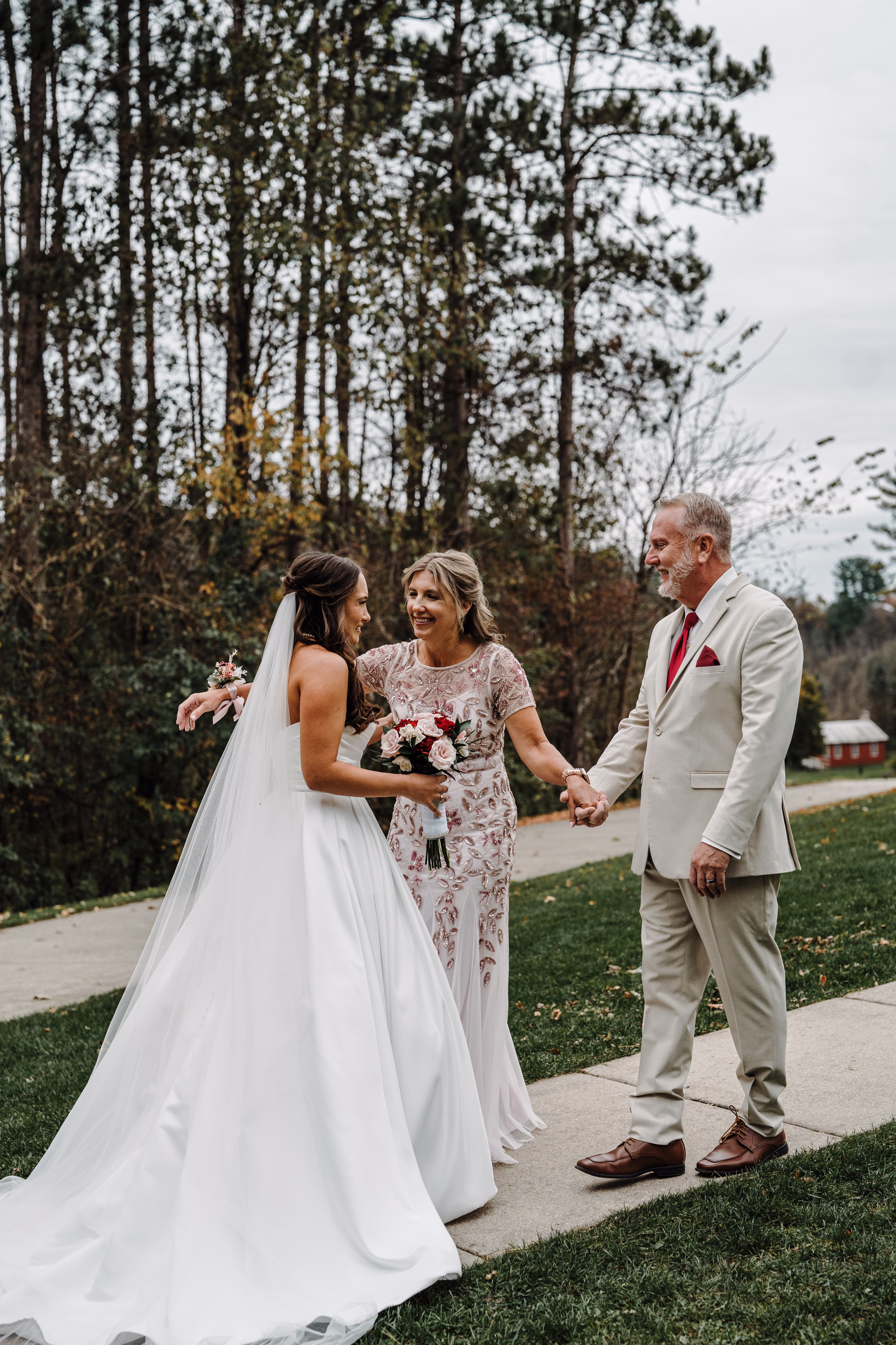 scenic fall wedding winnebago springs minnesota first look 0674 - An Elegant Fall Wedding at Winnebago Springs | Emma & Tyler mother and father of the bride smile and embrace her during a parents' first look at her wedding