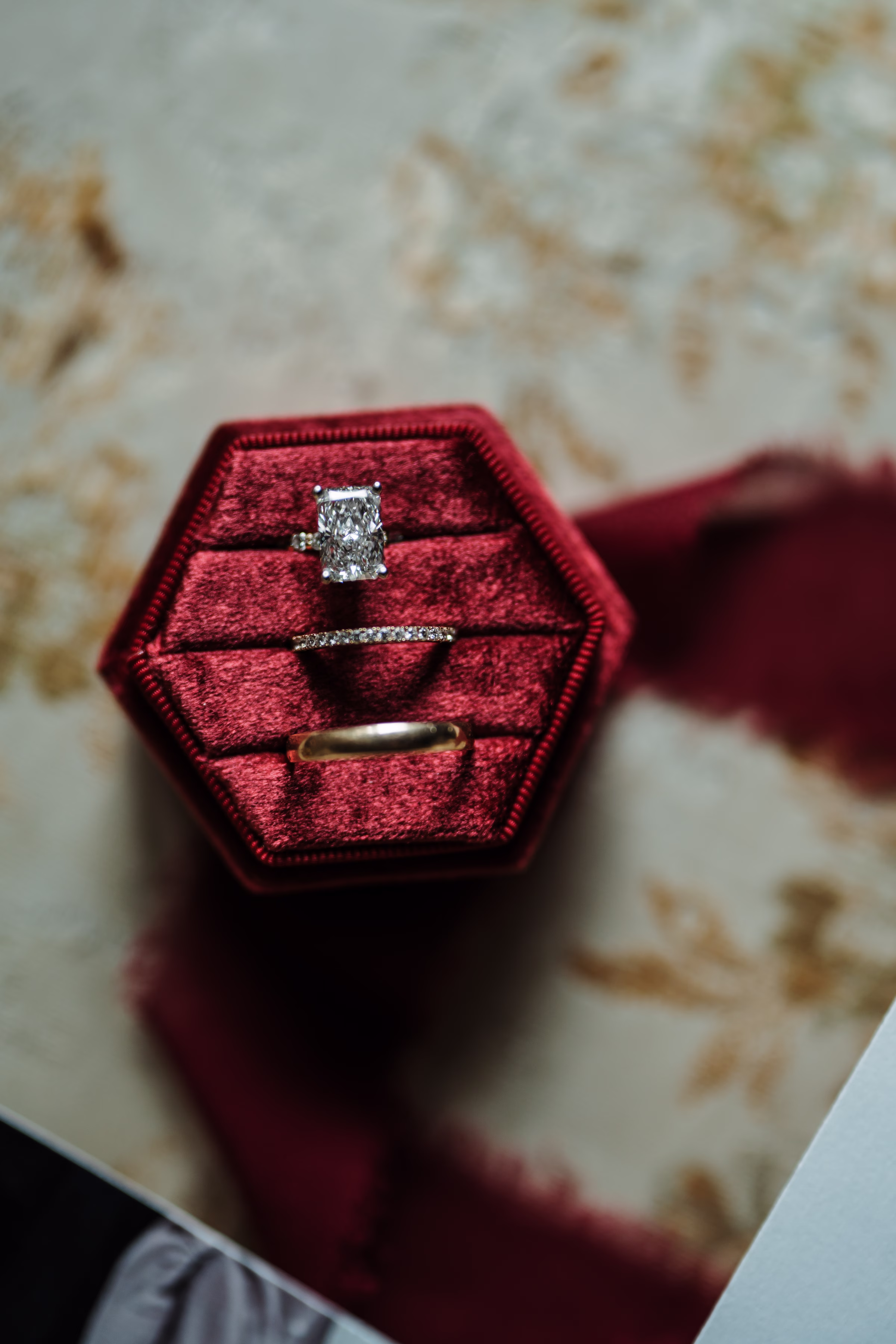 scenic fall wedding winnebago springs minnesota rings 3421 - An Elegant Fall Wedding at Winnebago Springs | Emma & Tyler a close-up photo of bridal rings in hexagonal, red velvet ring holder